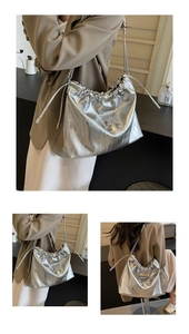 Viste dettagliate di una borsa a secchiello metallizzata argento con catena e fiocco decorativo