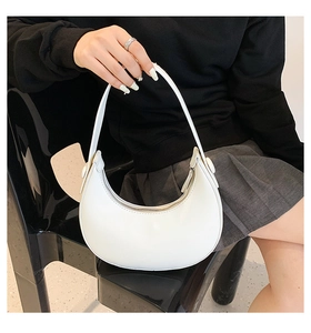 Close-up of white minimalist crescent bag on a model showing the smooth leather finish