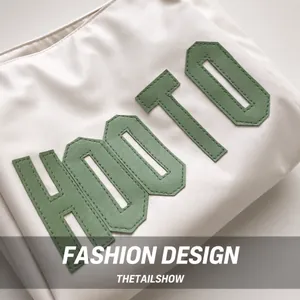 Macro shot of stitched green HOOTO lettering on cream fabric of a large tote bag