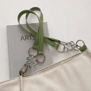Detailed shot of sage green leather handle with silver metal chain on a white tote bag