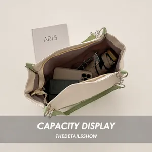 Top view of large cream tote bag with green straps showing spacious interior and items