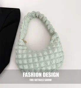 Detail view of mint green hobo bag with bubble textured fabric and gold zipper