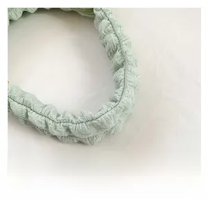 Close-up of light green cloud-shaped gathered fabric handle with ruched plaid texture
