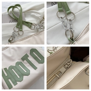 Detail of HOOTO large tote bag with silver chain strap and metal zipper on white fabric