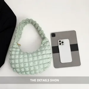 Green pleated hobo bag shown next to an iPad and iPhone for size comparison