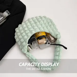 Detail showing inner capacity of the light green waffle textured shoulder bag