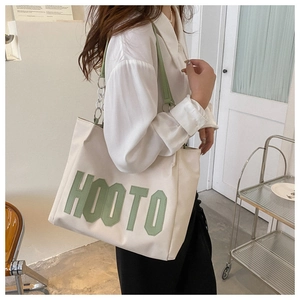 Detail of canvas tote bag with 3D HOOTO lettering and metal chain shoulder strap