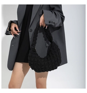 Detail shot of black quilted bubble texture shoulder bag with stylish pleated fabric finish