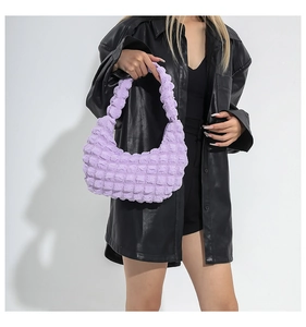 Close-up of lavender bubble textured handbag with pleated square patterns on strap