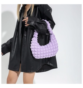Detail of light purple bubble textured hobo bag worn with black leather shirt