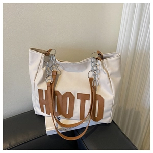 Detail of canvas tote bag with brown leather handles, metal chain and HOOTD print