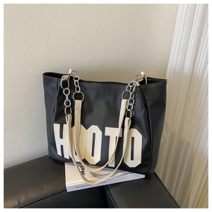 Detail of black PU leather tote with HOOTO letter patch and metal chain strap