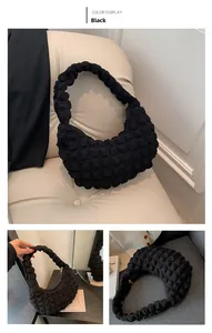 Detail view of black bubble textured fabric on a stylish crescent underarm handbag