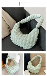 Detail of mint green cloud bag showing bubble texture and pleated fabric in a scene