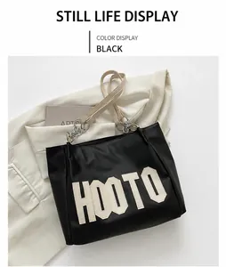 Close-up of black tote bag with HOOTO lettering and silver chain strap detail