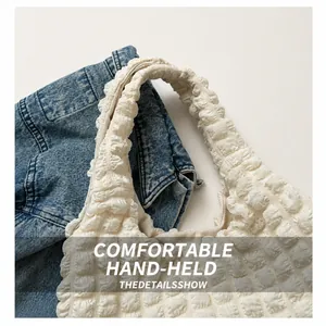 Close-up of the comfortable handle and bubble textured fabric on the white tote bag