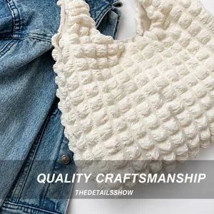 Close-up of white bubble texture fabric on a stylish pleated shoulder bag with soft padding