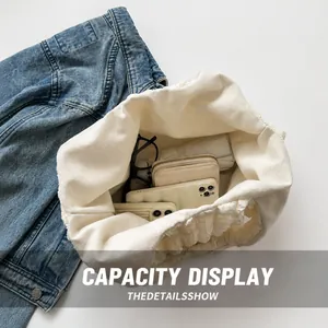 Top-down view of spacious white ruffled tote bag showing internal storage for phone and wallet