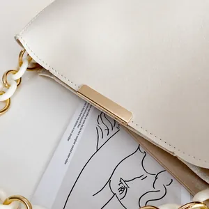 Détails de sac à main blanc grainé avec finitions dorées et bandoulière en chaîne élégante