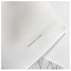 Détail du sac à main en cuir grainé blanc avec logo doré FHSNIQN & BAGS