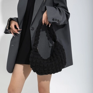 Minimalist black bubble texture tote bag with a modern wide handle shown on a model