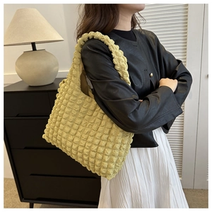 Close-up of bright yellow textured popcorn fabric tote bag styled in a home interior