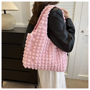 Detailed view of pink popcorn bubble texture fabric on a wide shoulder strap tote bag