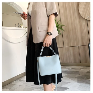 Détail du sac seau bleu clair avec poignée en chaîne acrylique sur un mannequin