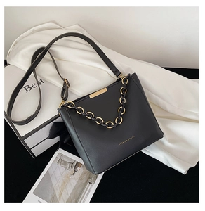 Détail du sac seau en cuir noir avec garniture dorée et poignée en chaîne