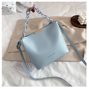 Détail du sac seau bleu clair avec poignée chaîne en plastique et fini texturé