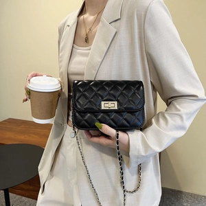 Schwarze gesteppte Leder-Umhängetasche mit Goldkette, präsentiert an einem Model