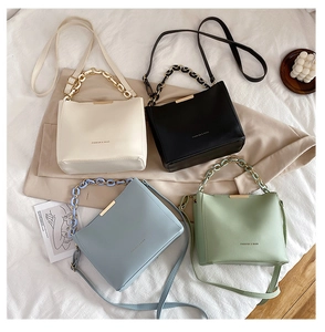 Sacs seaux à chaîne tendance en crème, noir, bleu clair et vert sur tissu