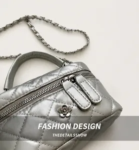 Detailed macro view of silver quilted leather box bag featuring camellia metal clasp