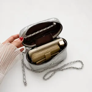 Interior view of silver quilted vanity case bag showing capacity for phone and lipstick