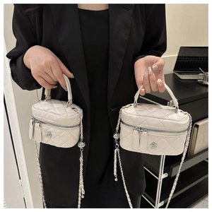 Close-up of cream quilted handbags with flower logo and chain strap in two sizes