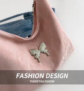 Close-up of pink cloud texture shoulder bag with large silver liquid metal butterfly