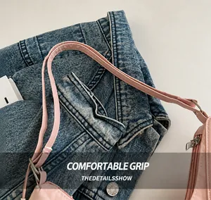 Close-up of pink PU leather handbag strap with reinforced stitching on denim background