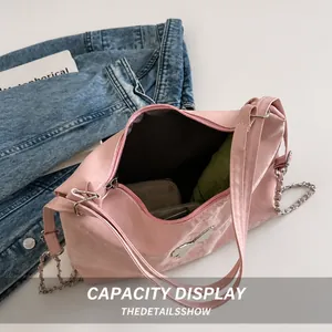 Pink shoulder bag interior showing capacity for umbrella and wallet with chain detail