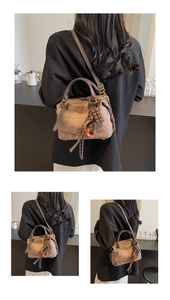 Detail view of vintage brown oil wax leather Boston bag with a chocolate charm and logo