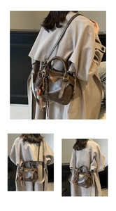 Detail of vintage oil wax leather shoulder bag with golden triangle logo and pendant