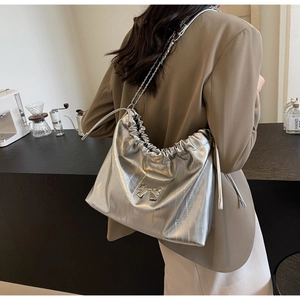 Dettaglio borsa shopper a pieghe argento metallizzato con tracolla a catena e fiocco