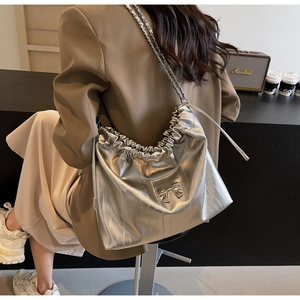 Dettaglio della borsa tote argento metallizzato con coulisse e ornamento a fiocco