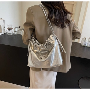 Dettaglio della borsa tote argento metallizzato con coulisse e fiocco in metallo