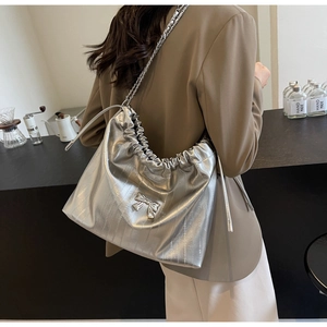 Dettaglio borsa tote plissettata argento con fiocco metallico e tracolla a catena