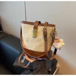 Detail van canvas emmertas met MINIMINI BAGS reliëflogo en fijne lederen textuur