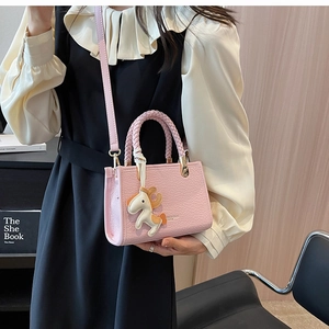 Pink crocodile pattern tote bag detail with woven handle and small pony charm