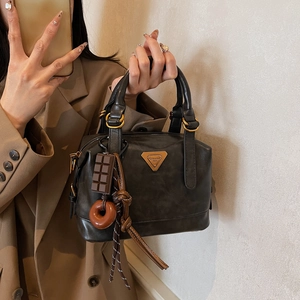 Retro brown oil wax leather shoulder bag with creative charms and a luxury metal plate