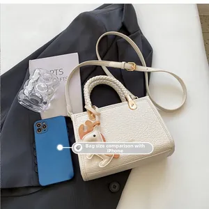 White croc-embossed tote bag size comparison with an iPhone showing internal capacity