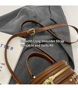 Detail of adjustable leather shoulder strap and gold buckle on houndstooth bucket bag