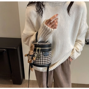 Houndstooth bucket bag shown on a model with a cute rabbit plush doll charm